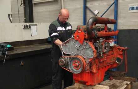 Teus Vlot monteur bezig met de reparatie van een Scania motor in de werkplaats van Teus Vlot
